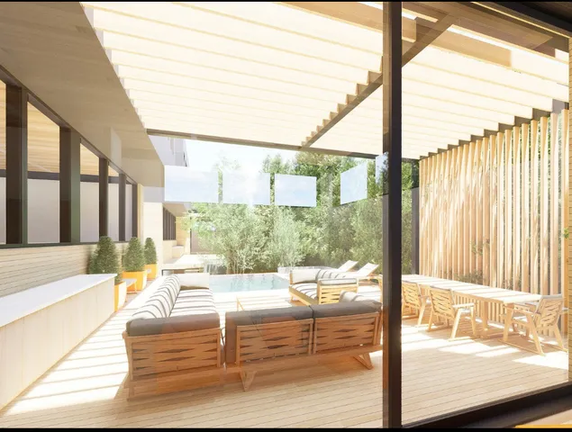 a roof deck with couches and potted plants with sky view