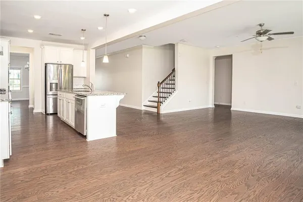a view of kitchen with stainless steel appliances a refrigerator and wooden floor
