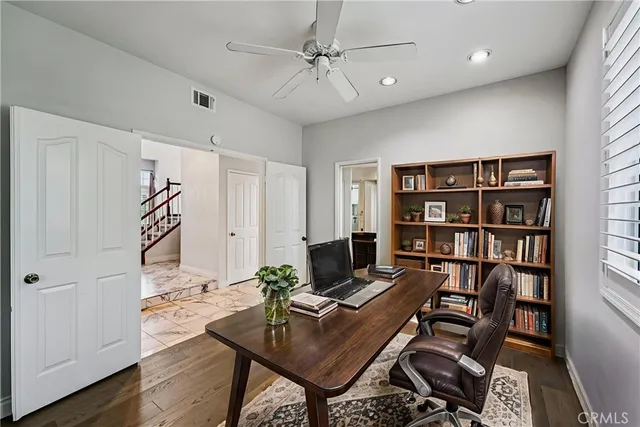 a workspace with a bookshelf and a window