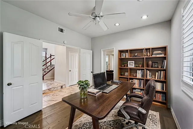 a workspace with a bookshelf and a window