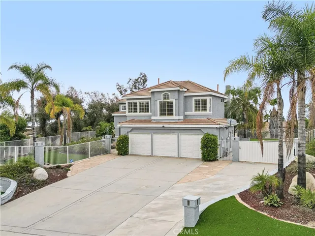 a front view of a house with a yard and potted plants