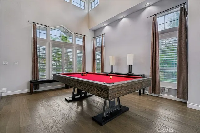a room with pool table windows and wooden floor