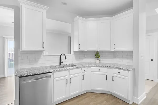 a kitchen with stainless steel appliances granite countertop white cabinets sink and dishwasher