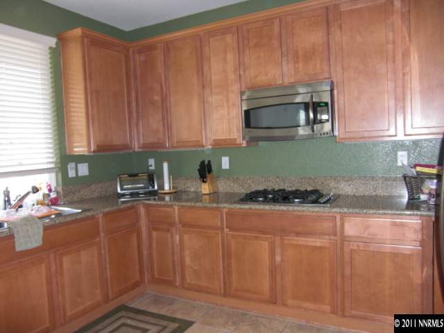 14044 Tagor Road Reno, NV 89521 - Photo 2 of 12 a kitchen with stainless steel appliances granite countertop a stove a sink and a microwave