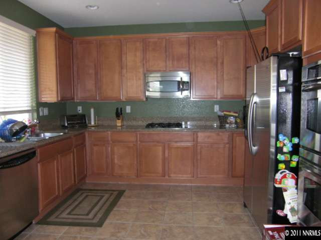 14044 Tagor Road Reno, NV 89521 - Photo 3 of 12 a kitchen with stainless steel appliances granite countertop a refrigerator and a sink