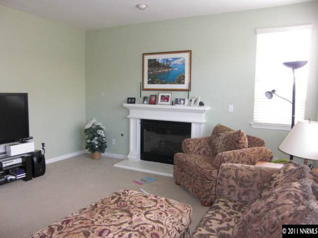 14044 Tagor Road Reno, NV 89521 - Photo 10 of 12 a living room with furniture a flat screen tv and a fireplace
