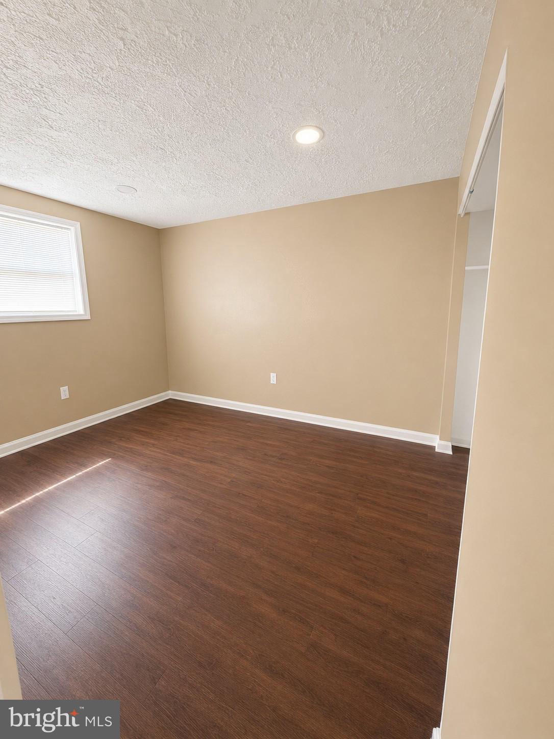 6204 Cipriano Road Lanham, MD 20706 - Photo 16 of 19 an empty room with wooden floor and windows
