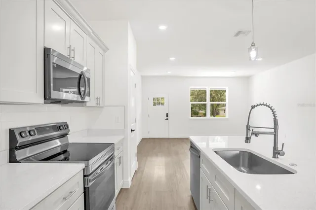 a kitchen that has a sink and a stove top oven
