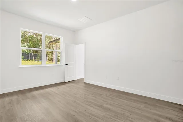 a bedroom with a large bed and a potted plant