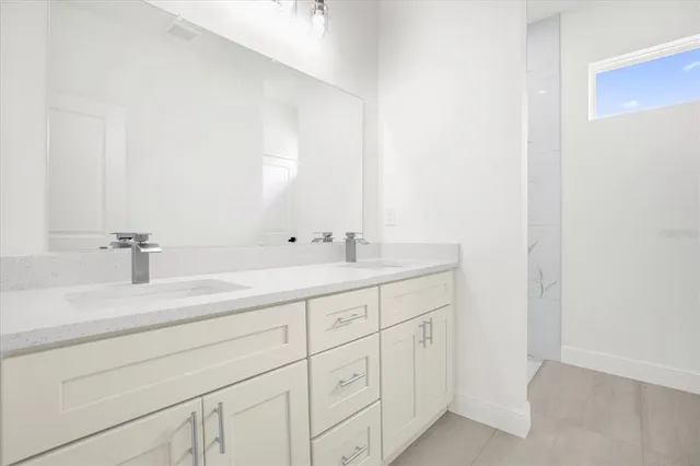 a bathroom with a shower sink and mirror
