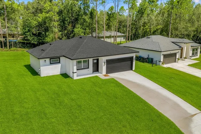 a aerial view of a house with a yard table and chairs