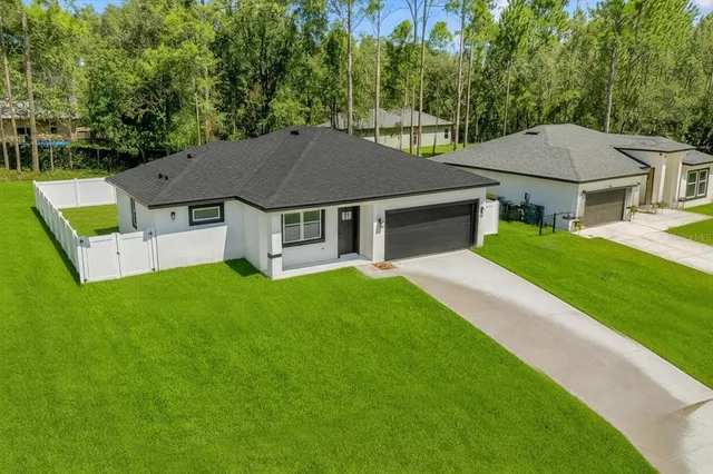 a aerial view of a house with a yard table and chairs