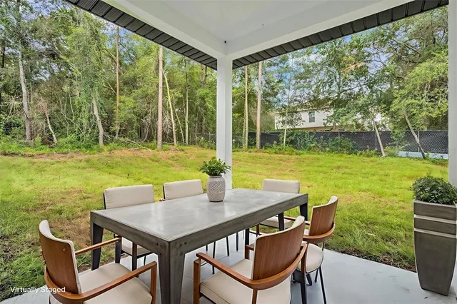 a house that is sitting in the grass with large trees