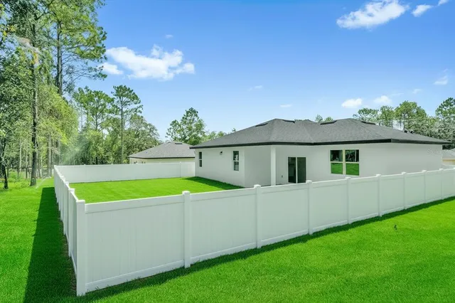 an aerial view of residential houses with outdoor space and trees