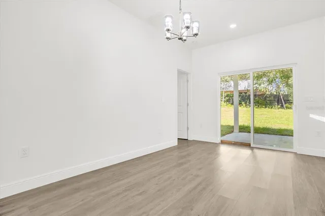 an empty room with wooden floor and sliding door