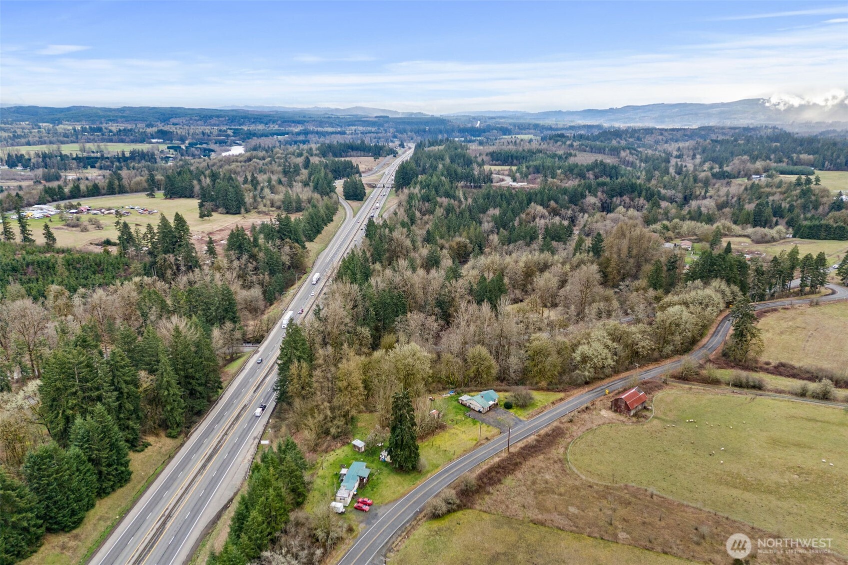 an aerial view of a residential houses with outdoor space and trees