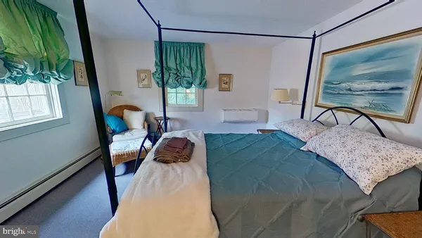 a bedroom with a bed a lamp and a large window