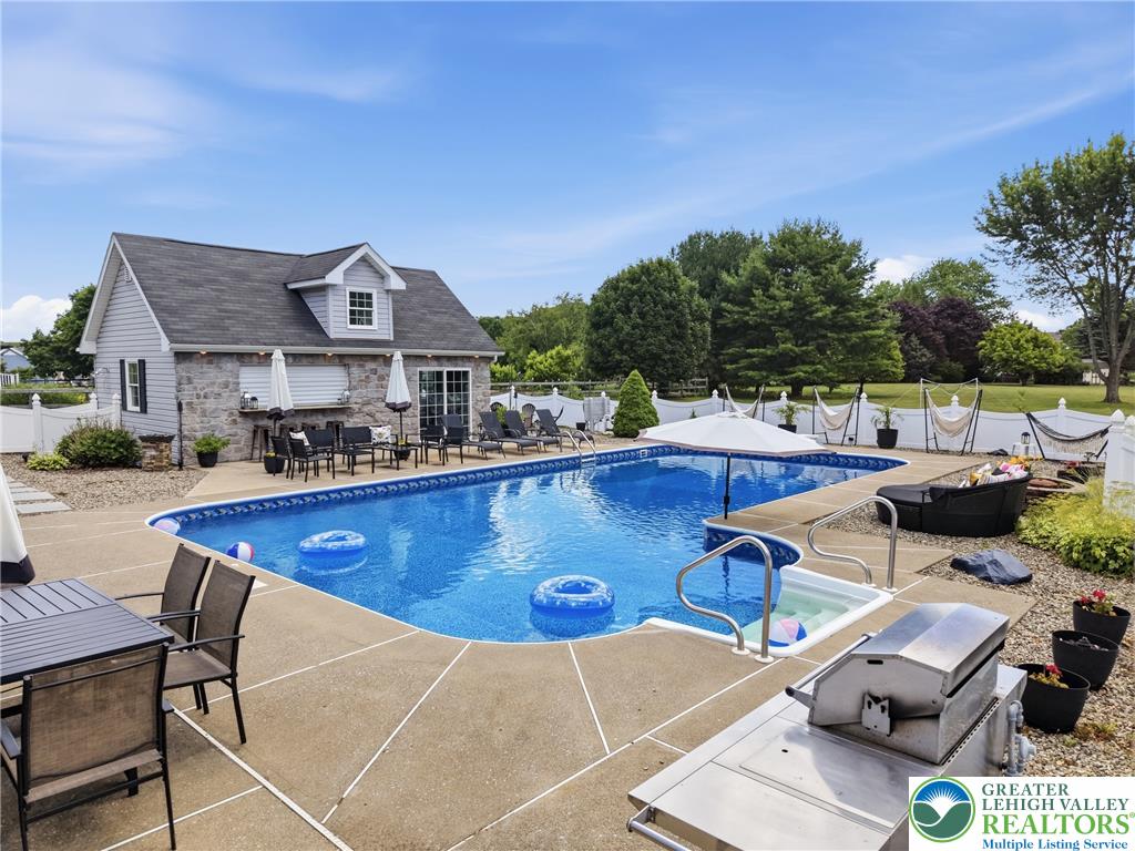 890 Lahr Road Nazareth, PA 18064 - Photo 48 of 71 An inviting backyard oasis offers a sparkling pool and spa, ideal for relaxation and entertaining.