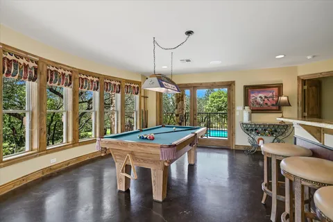 a dining room with wooden floor a chandelier a wooden table and chairs