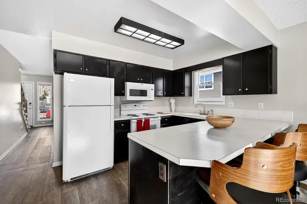 a kitchen with stainless steel appliances a refrigerator a stove a microwave a dining table and chairs