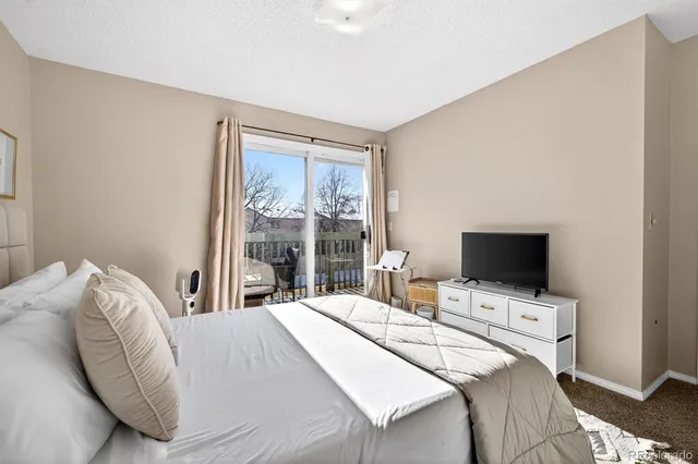a bedroom with a bed and a flat tv screen on the dresser
