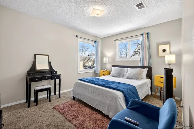 a bed room with a bed and painting on the wall