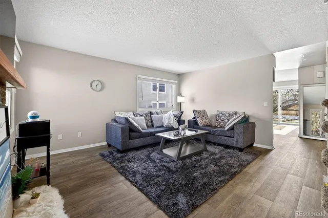 a living room with furniture wooden floor and a window