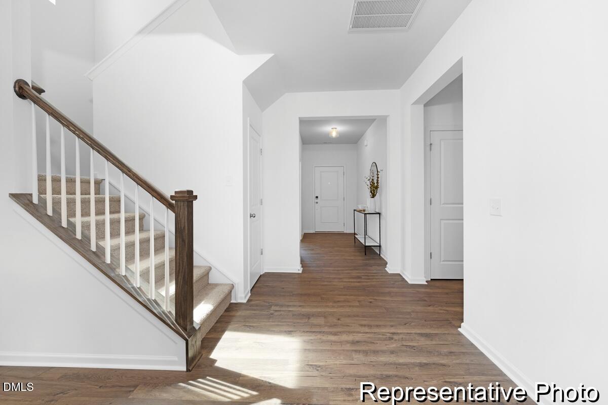 47 Flicker Lane, Unit 188P Angier, NC 27501 - Photo 33 of 38 a view of a hallway with wooden floor and staircase