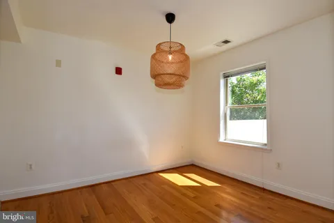 a view of a small space with wooden floor and a window