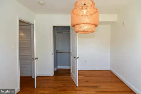 an empty room with wooden floor and cabinet