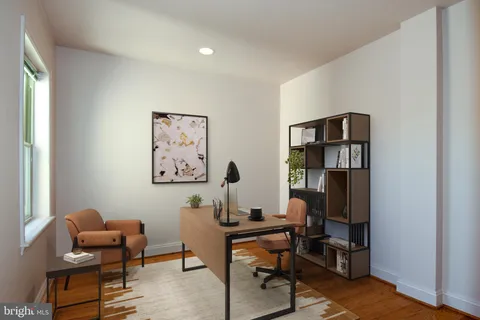 a view of a workspace with furniture and a window