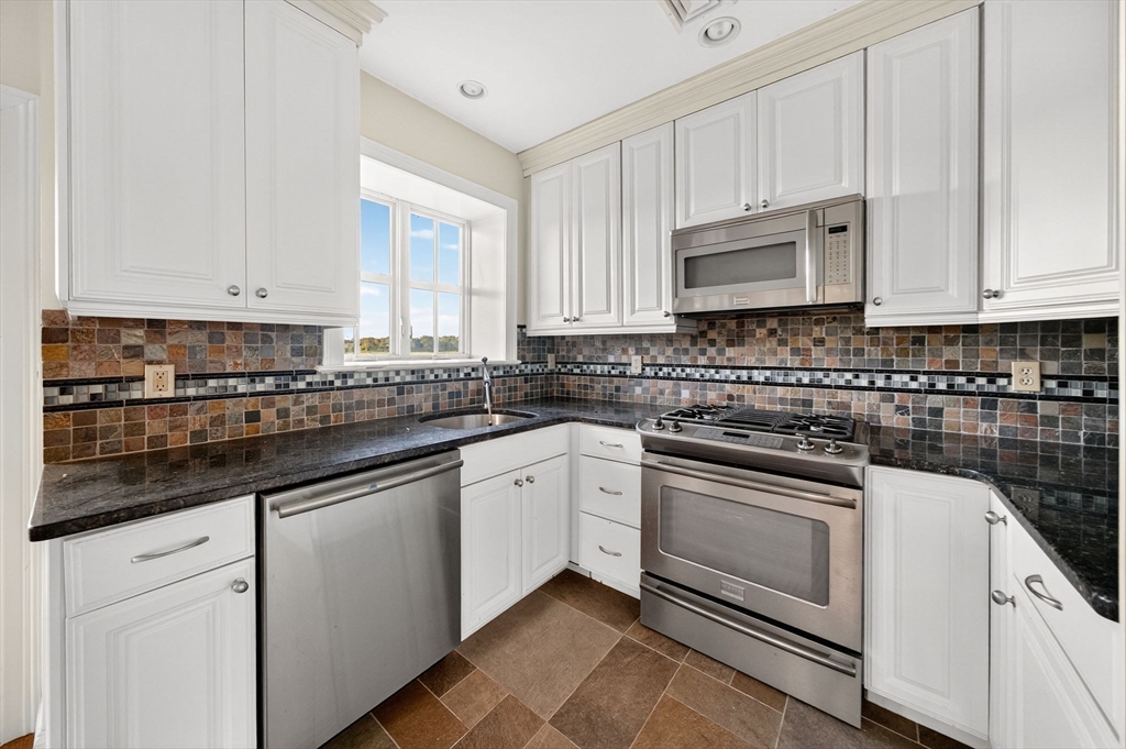 12 Quentin Street Milton, MA 02186 - Photo 38 of 41 a kitchen with granite countertop white cabinets and white stainless steel appliances