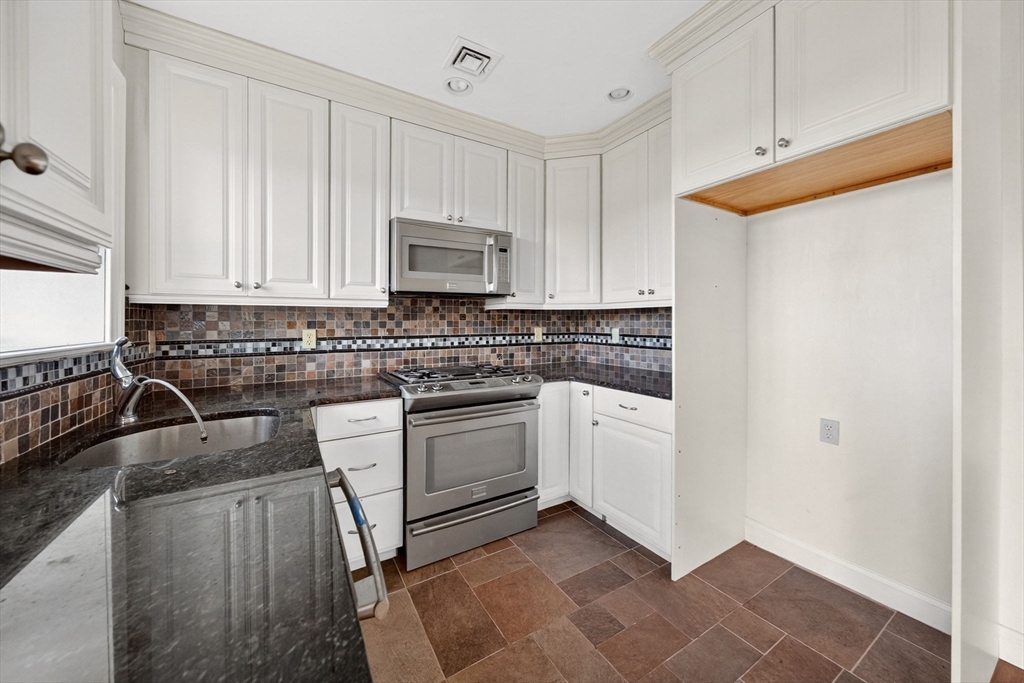 12 Quentin Street Milton, MA 02186 - Photo 39 of 41 a kitchen with granite countertop a sink a stove and cabinets