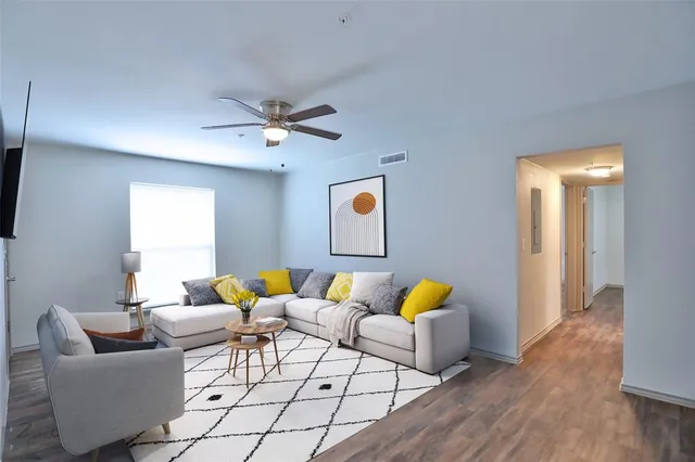 a living room with furniture and wooden floor