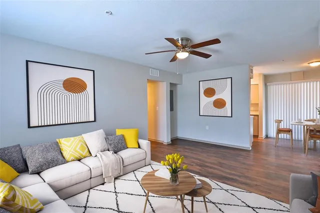 a living room with patio furniture and wooden floor