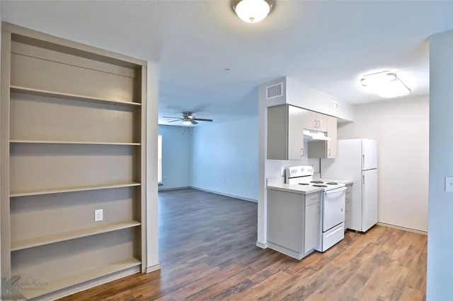 a kitchen with stainless steel appliances a stove and white cabinets