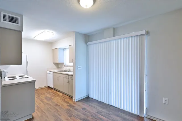 a kitchen with stainless steel appliances granite countertop a stove a sink and a refrigerator with wooden floors