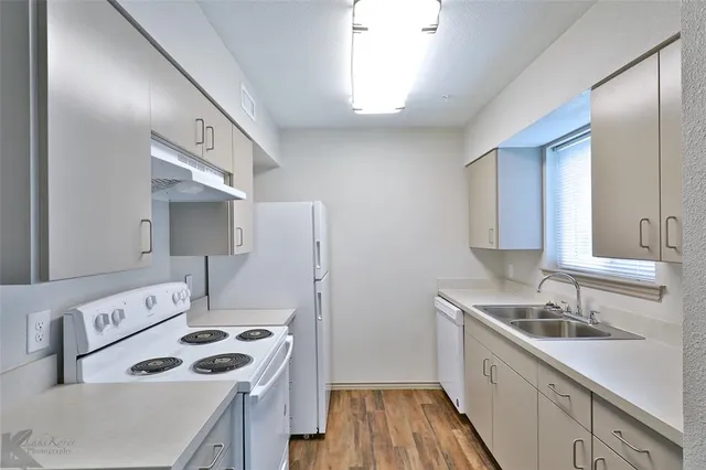 a kitchen that has a sink a stove and refrigerator