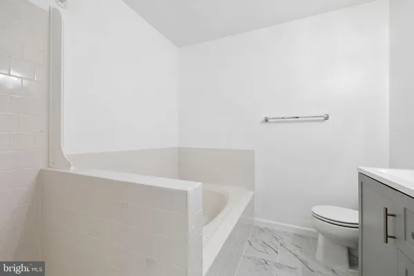 a bathroom with a toilet sink vanity and mirror