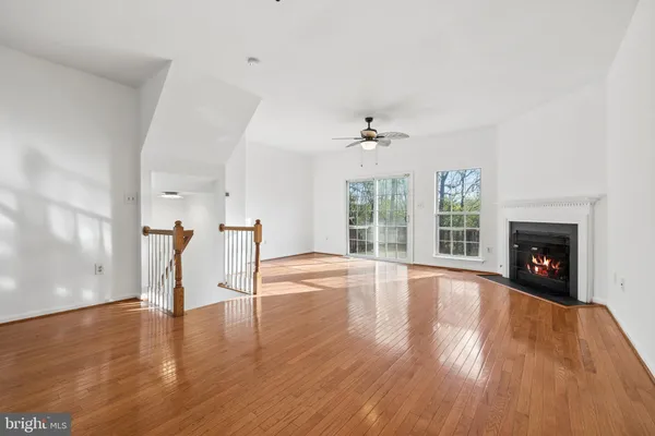 a view of empty room with wooden floor and fireplace