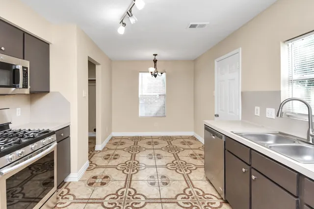 a kitchen with stainless steel appliances granite countertop a sink stove and cabinets