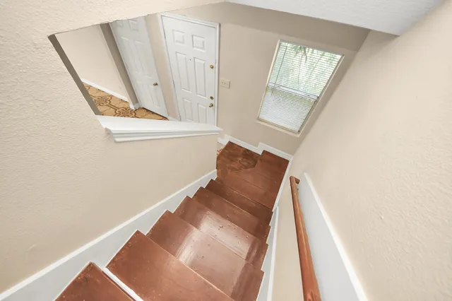 a view of a bedroom with wooden floor and stairs