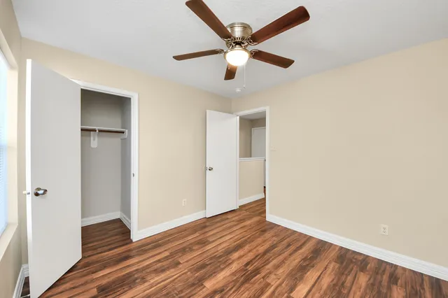 a view of wooden floor and a chandelier fan in a room
