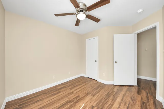 a view of a room with wooden floor and a ceiling fan