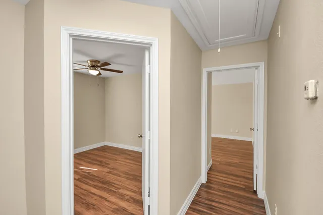 a view of a hallway with wooden floor and closet