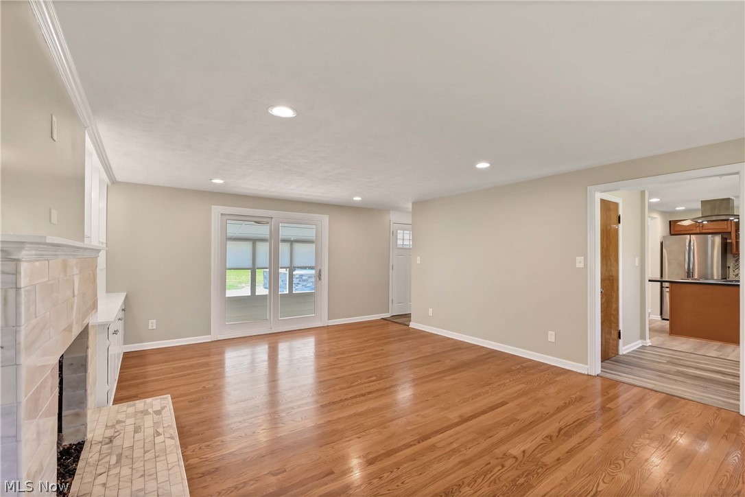 29514 Ridge Road Wickliffe, OH 44092 - Photo 13 of 49 Unfurnished living room with a tiled fireplace and light wood-type flooring