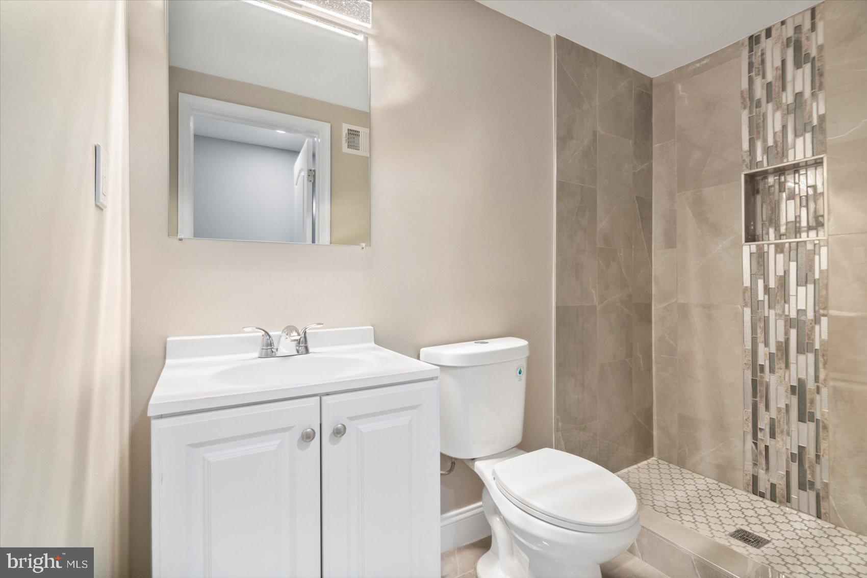 2901 Edison Highway Baltimore, MD 21213 - Photo 26 of 52 a bathroom with a toilet a sink a vanity and mirror