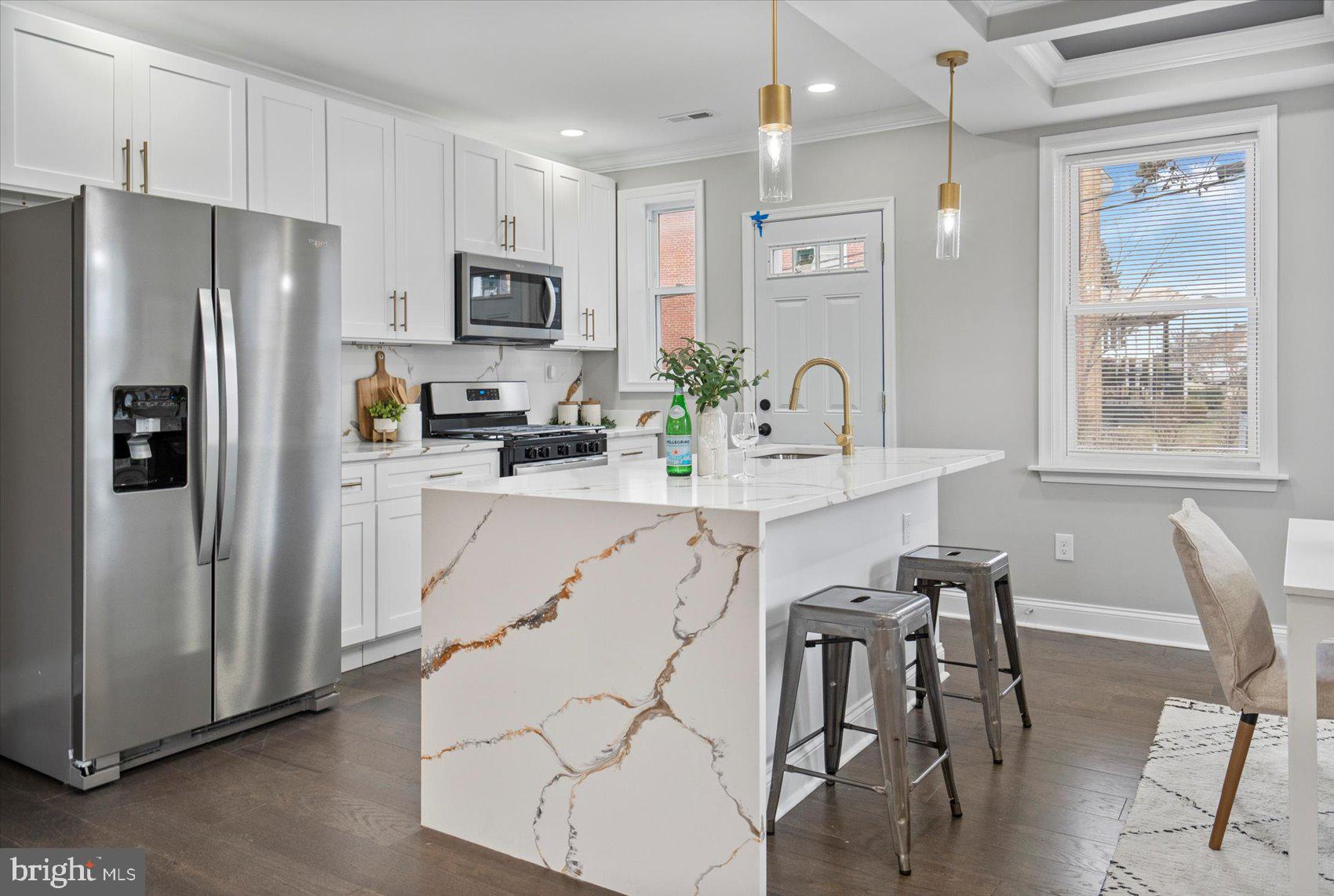 2901 Edison Highway Baltimore, MD 21213 - Photo 7 of 52 a kitchen with stainless steel appliances a refrigerator a stove a dining table and chairs