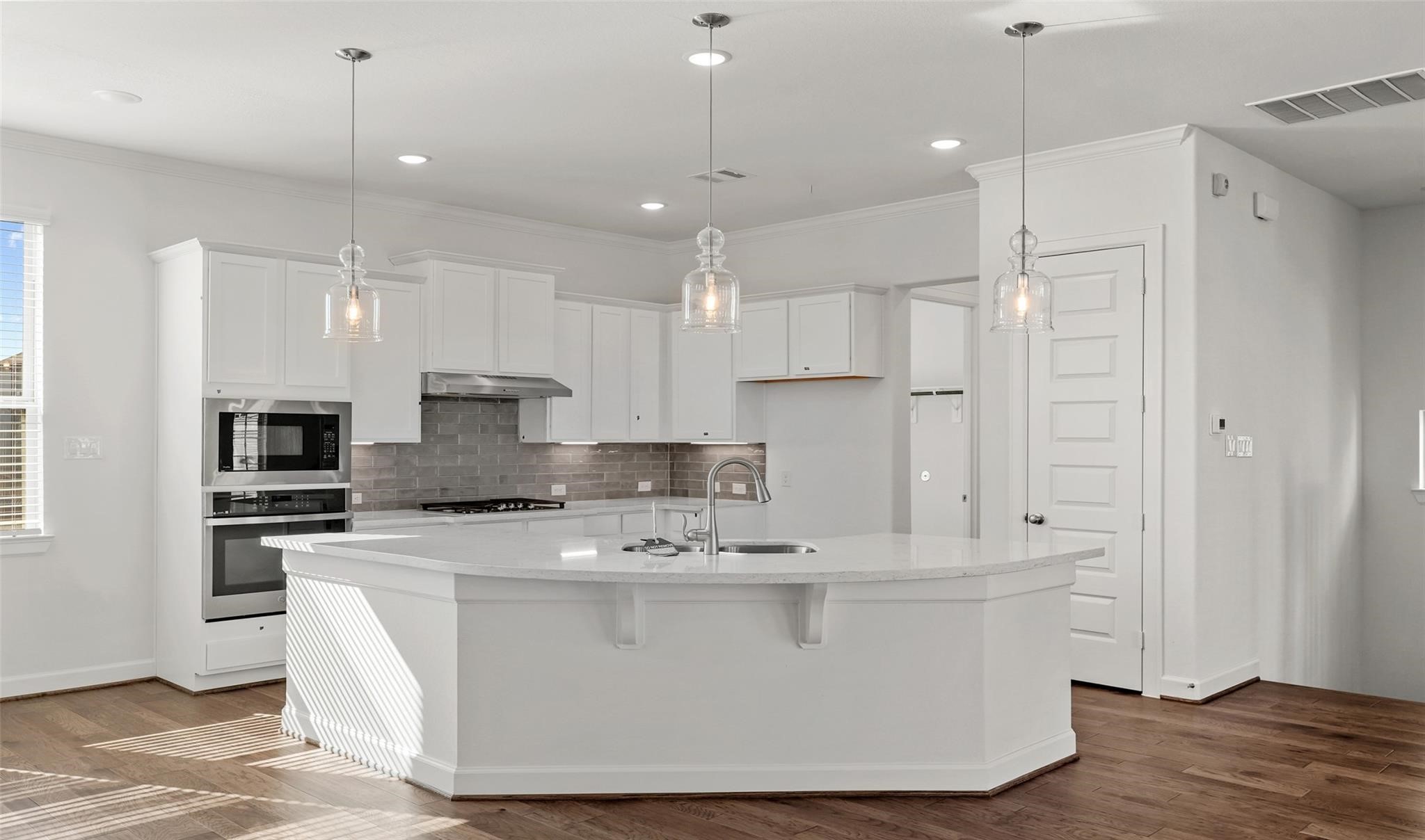 10609 Centre Green Way Houston, TX 77043 - Photo 5 of 27 a white kitchen with stainless steel appliances granite countertop a stove a sink a refrigerator and white cabinets with wooden floor