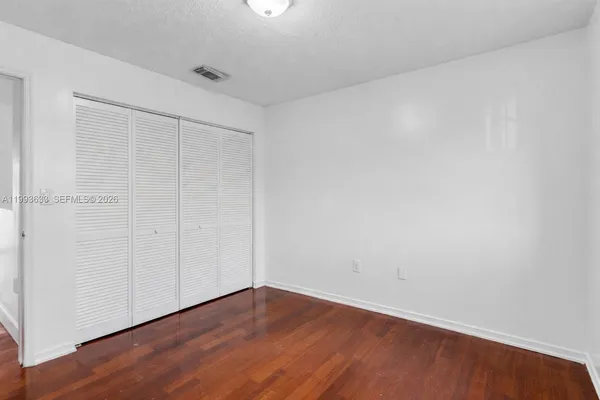 a view of an empty room with wooden floor